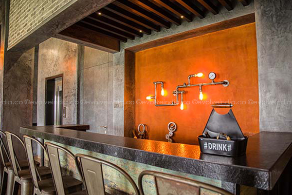 Bar wall designed with corten steel and decorative concrete finish by Evolve India