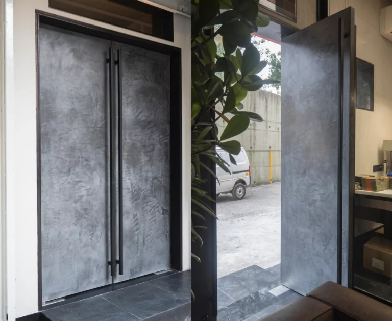 Entrance door designed with decorative concrete finish by Evolve India
